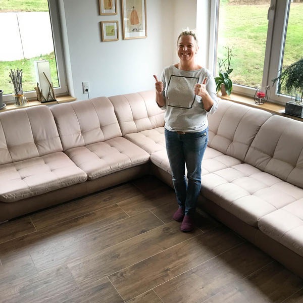 Zufriedene Kundin vor ihrem gereinigten Sofa