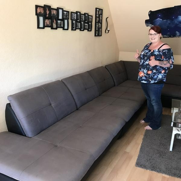Zufriedene Kundin vor ihrem gereinigten Sofa